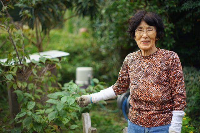 Older woman standing in the garden and smiling