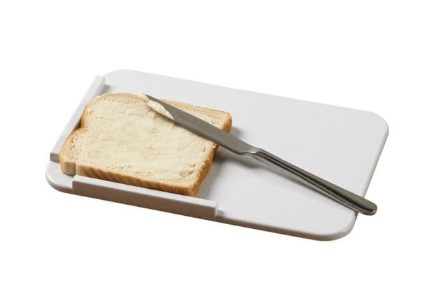A piece of bread on a buttering board