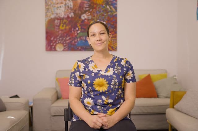 Support worker Choice sitting in her client's living room, smiling.