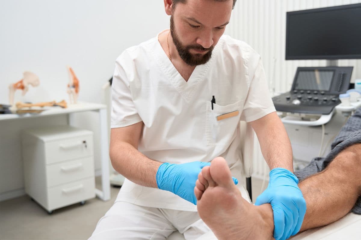 A health professional examining a patient's foot.