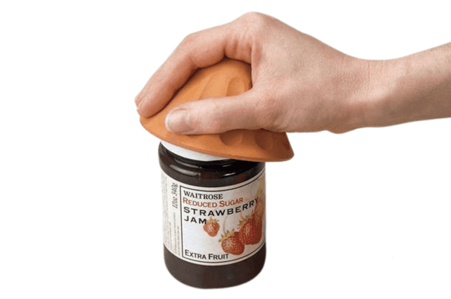 An orange dome-shaped device being used to open a jar lid