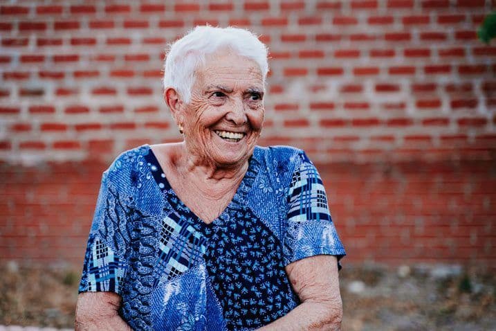 An older woman with short hair standing outside and smiling