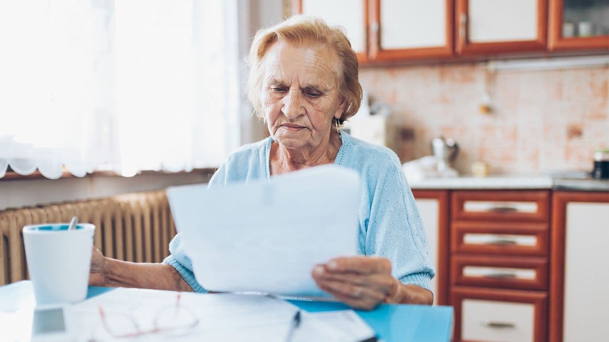 Older woman reading in kitchen 