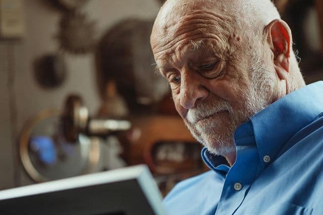 Older man staring at photograph