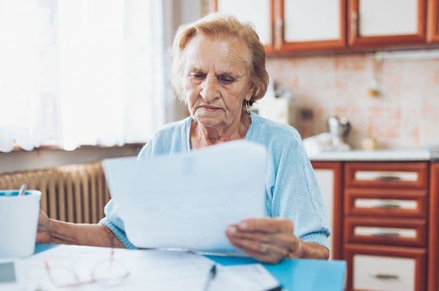 Older woman reading in kitchen 