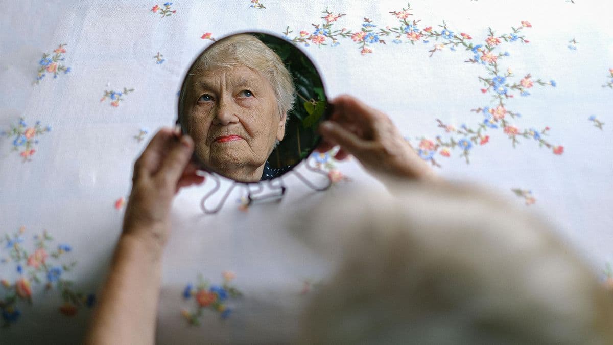 Older woman with handheld mirror