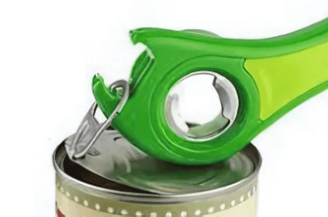 A green ring pull can opener being used to open a ring pull can