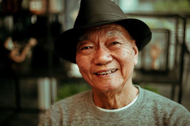 An older man smiling warmly to the camera