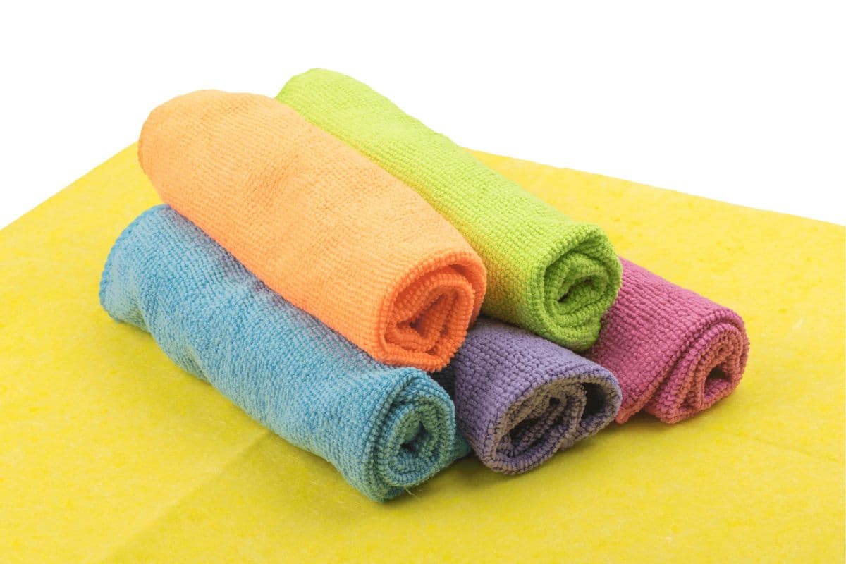 A neatly rolled pile of differently coloured microfibre cloths