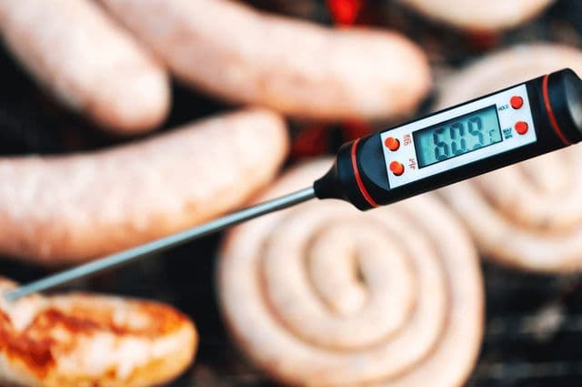 A thermometer being used to measure the temperature of meat