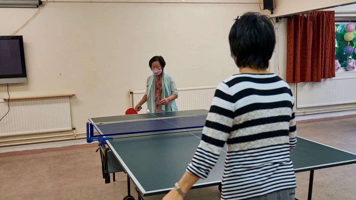 Two older women playing table tennis