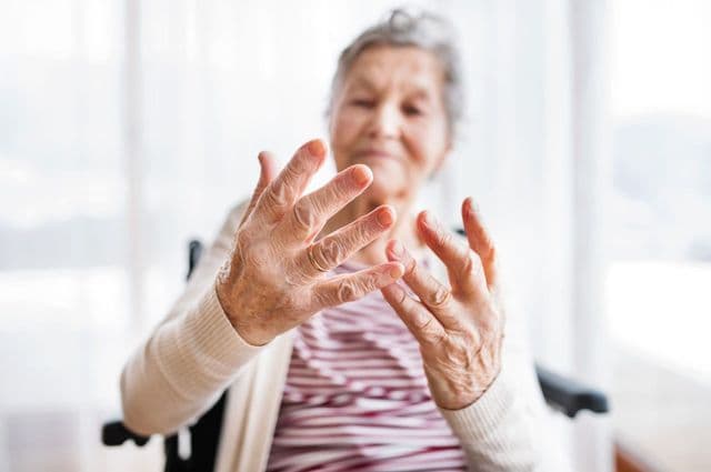 Elderly lady sat in a wheelchair exercising fingers