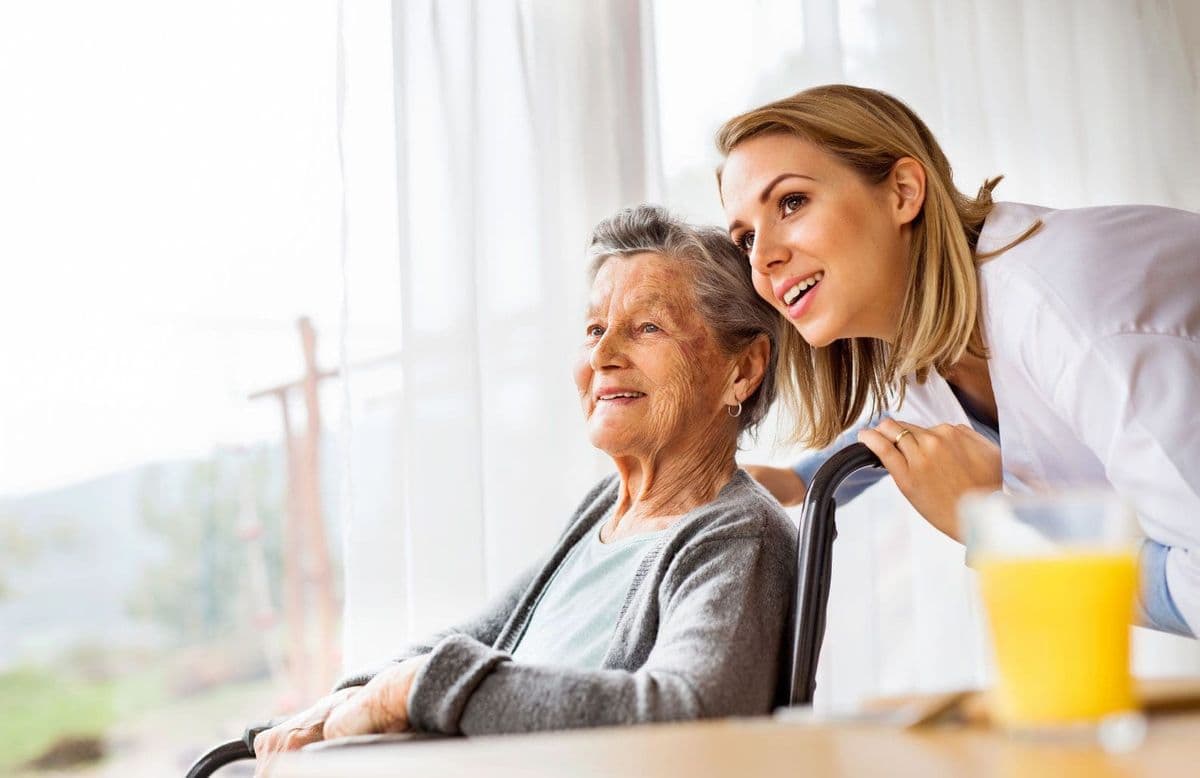 Support worker and elderly lady in a wheelchair inside