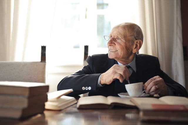 older man stirring a cup of tea