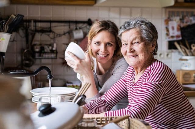 elderly lady washing-up-with granddaughter