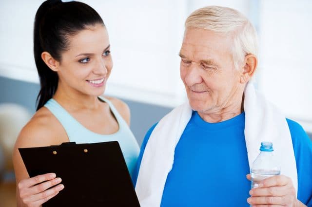 A health instructor discussing fitness plans with an older man.