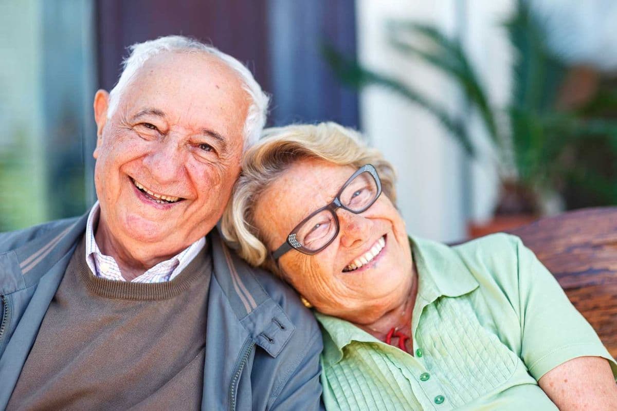 Older couple sitting next to each other and smiling