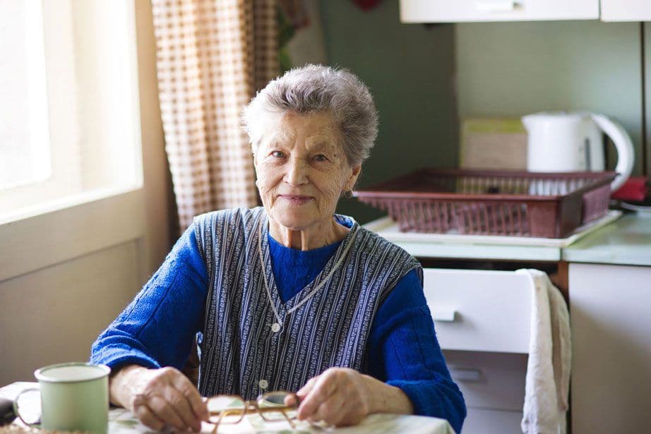 Older woman sitting at a table in the kitchen
