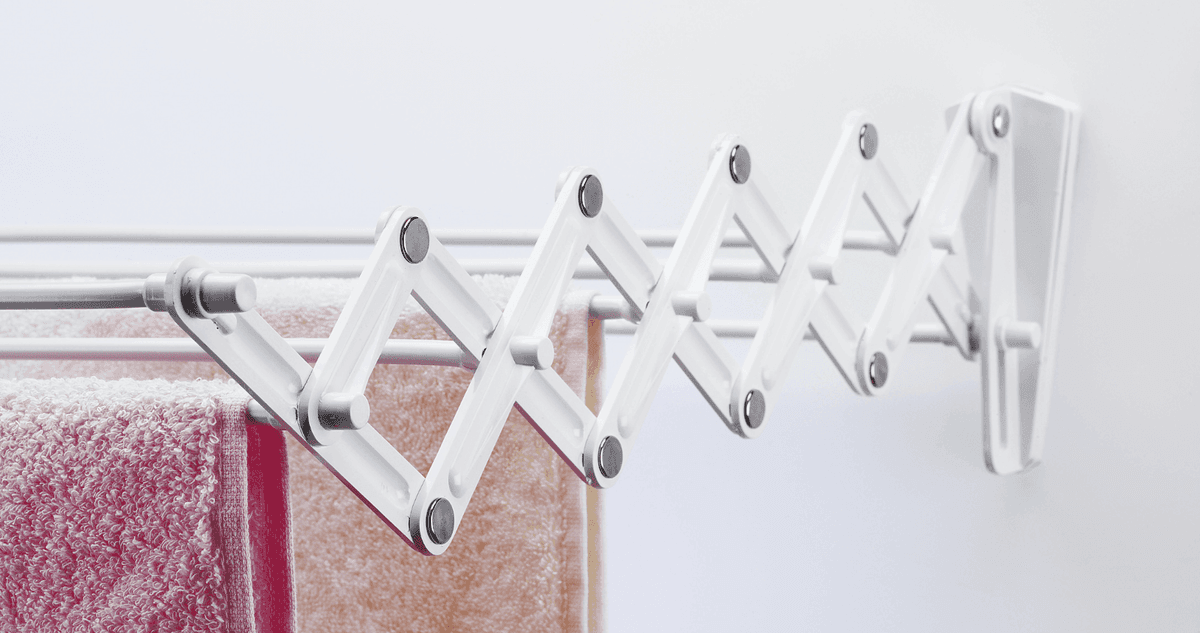 A wall mounted drying rack holding some towels