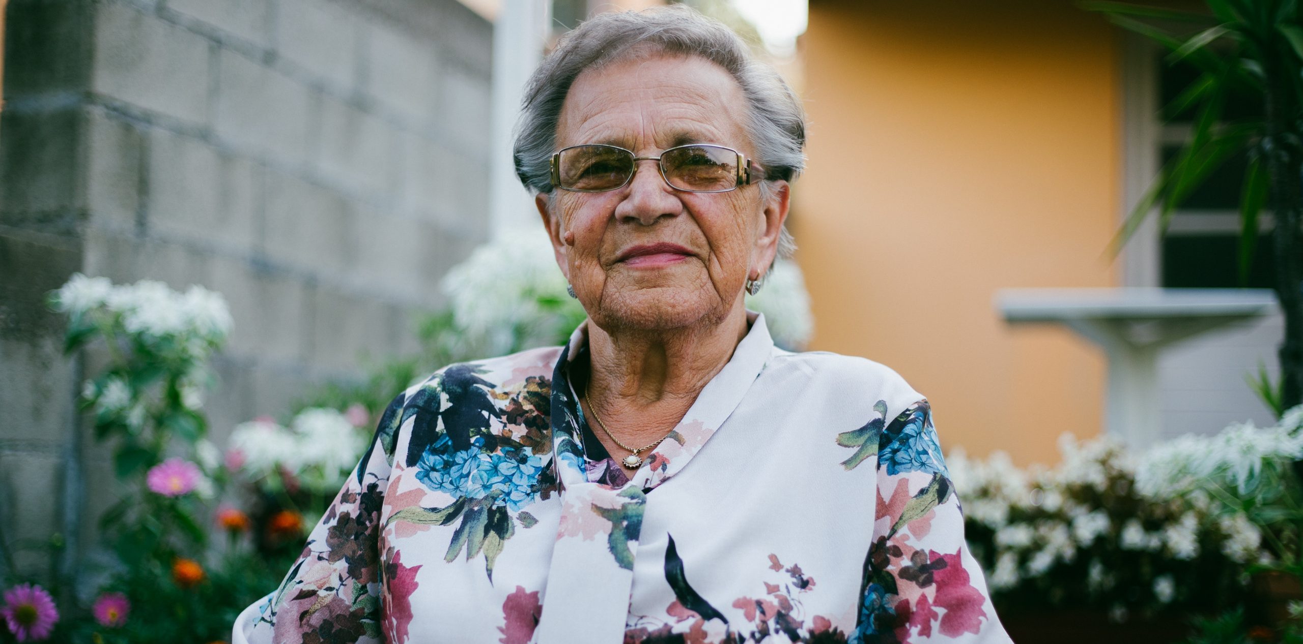 Elderly lady in a flowery top outside