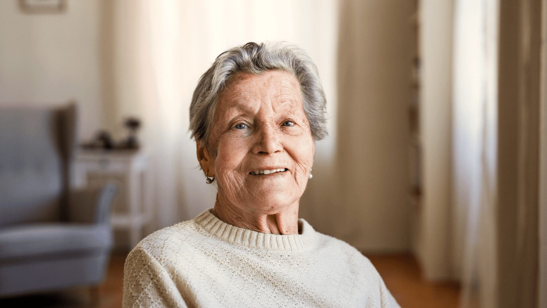 Elderly lady at home looking into camera