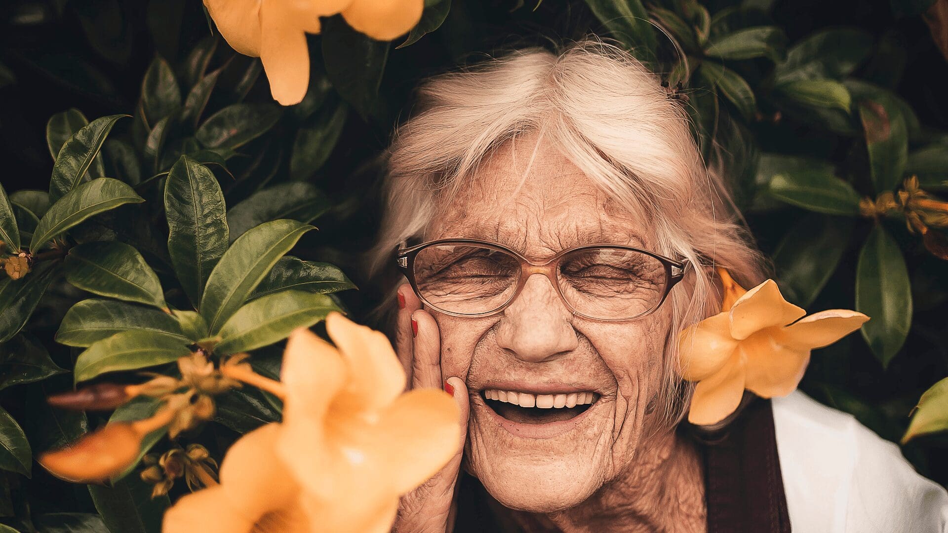 Elderly lady smiling in flowers