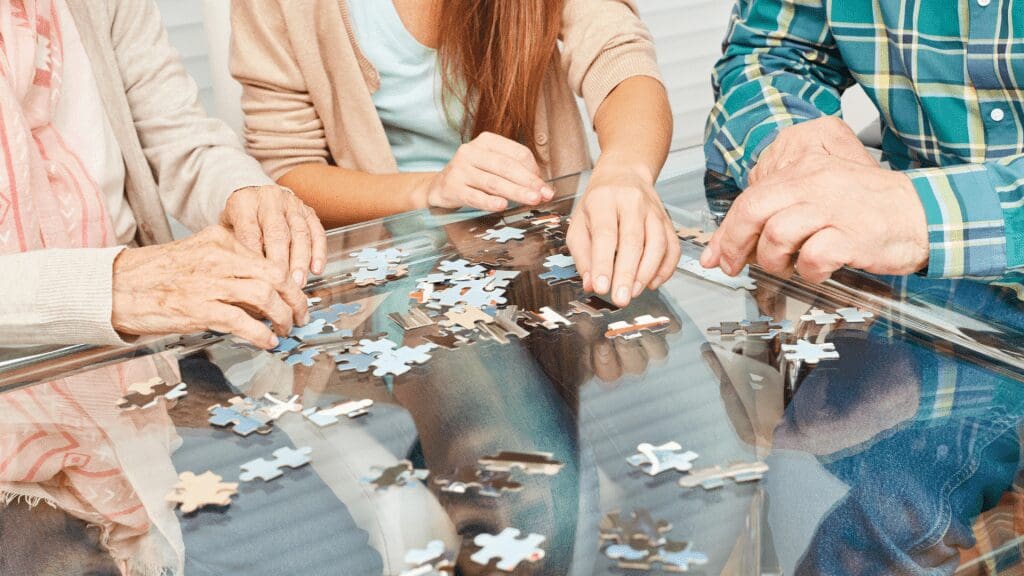 Support worker and clients doing a jigsaw